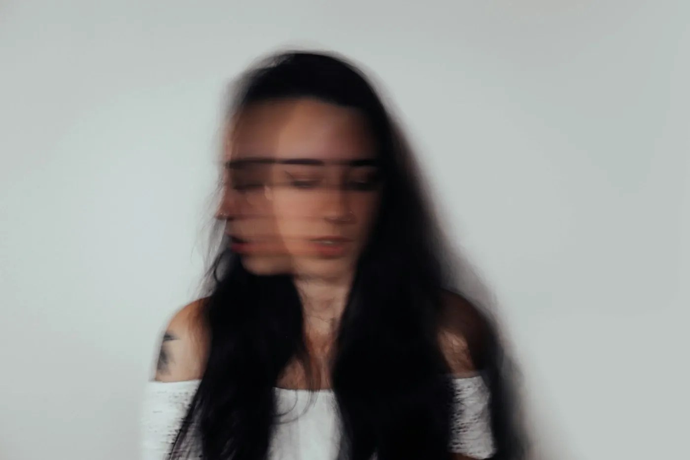 Blurred portrait of a woman, conveying anxiety and racing thoughts