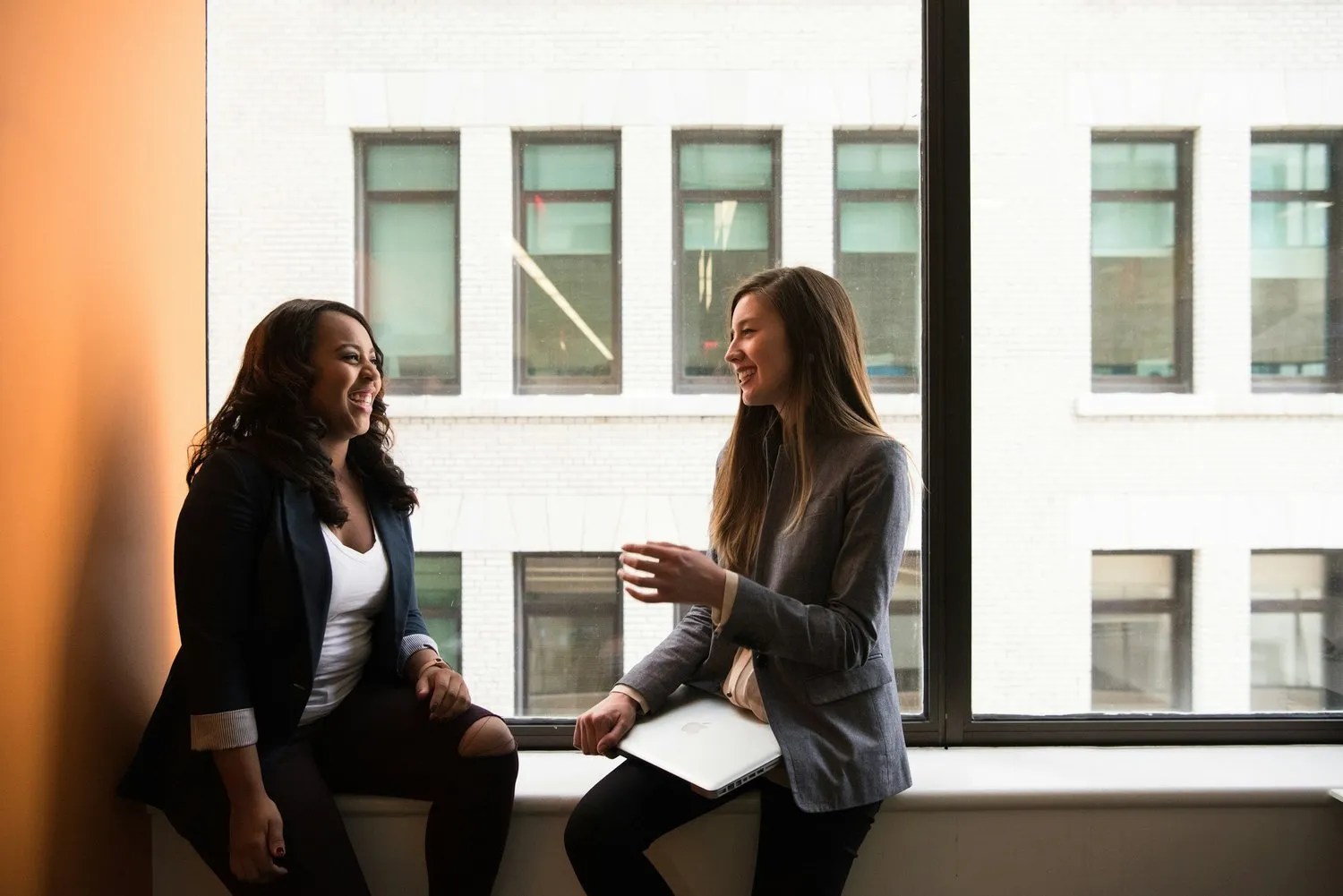 Two colleagues talking by a window